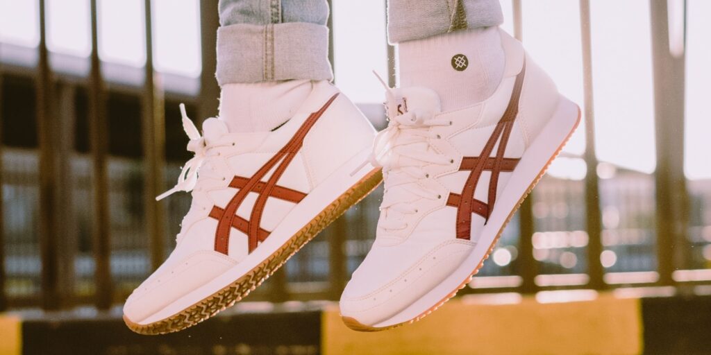 white Asics sneakers with brown logo on the side