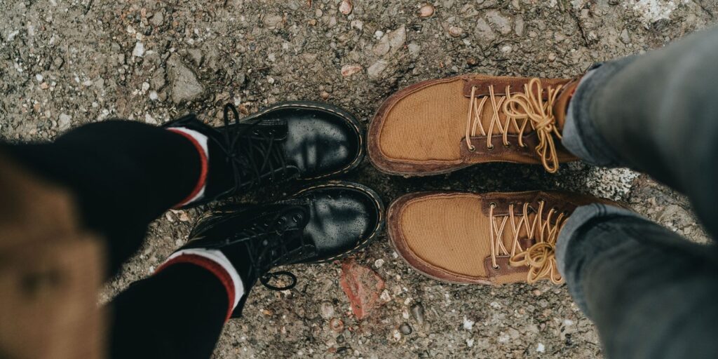camera looking down at two people's feet that are wearing dr.martens