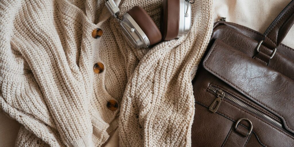 brown cardigan, headphones and a brown leather bag