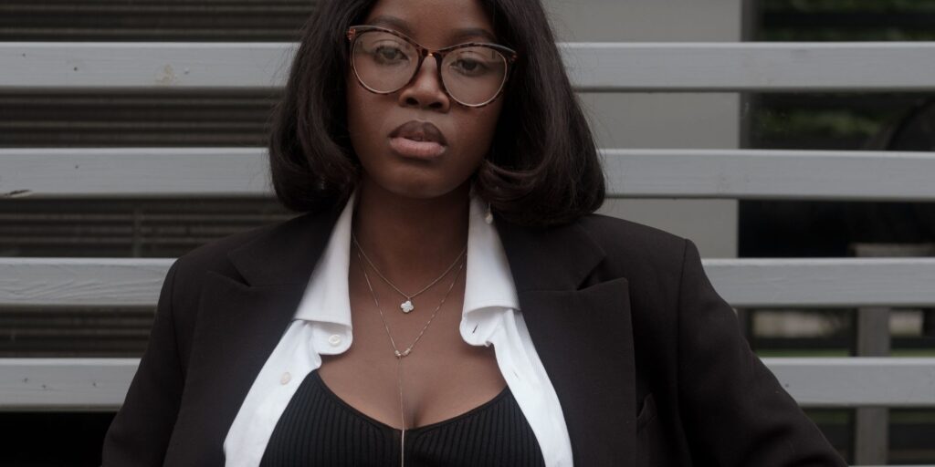 Profile of woman wearing black and white business casual attire and a silver necklace