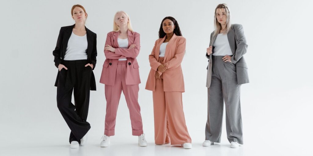 Four women dressed in business casual matching style suits are dress to impress