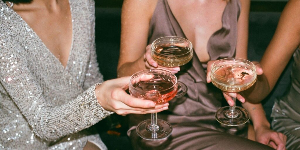 Three women having cocktails in beautiful dresses