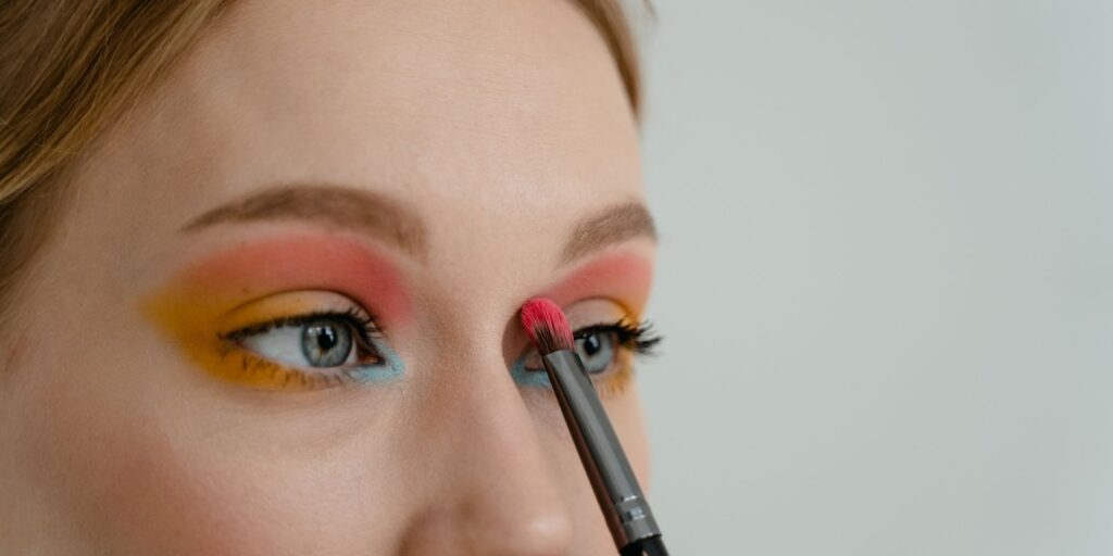 A woman applying colourful eyeshadow