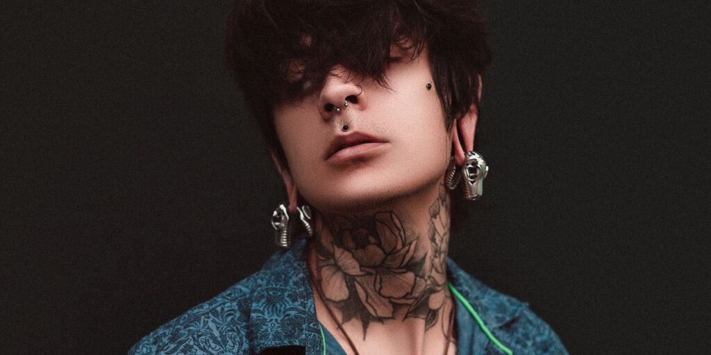 A man with a cool neck tattoo and peircings