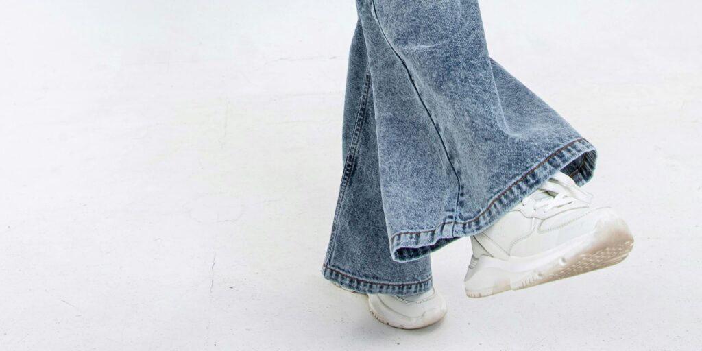 flared legged jeans from knee down and white sneakers