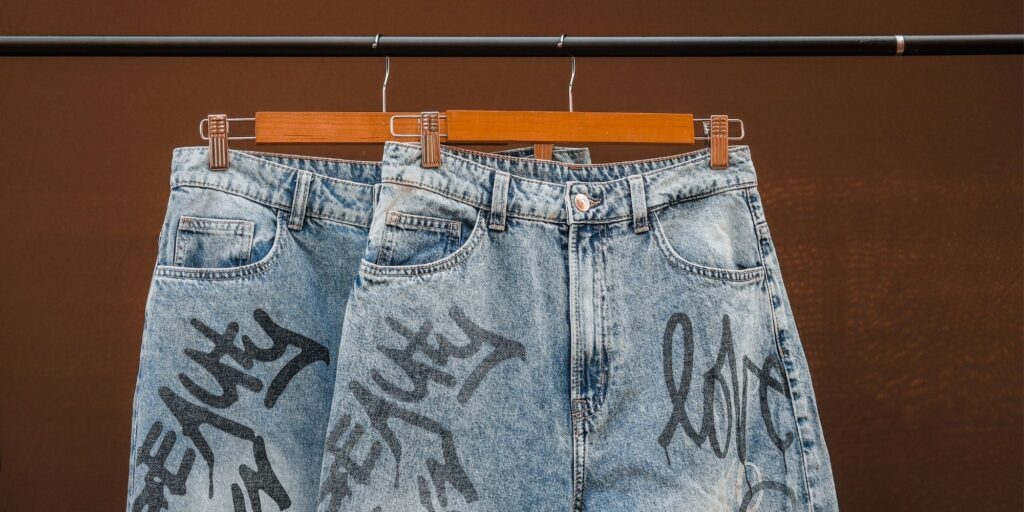 Two pairs of Ksubi jeans with graffiti on them