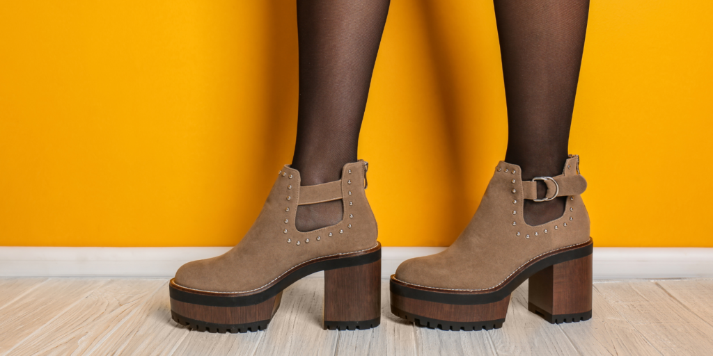 Ankle boot high heels against a yellow wall