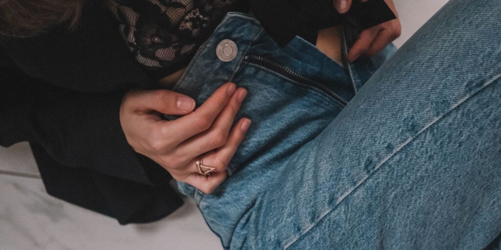Woman trying to do up her denim jorts