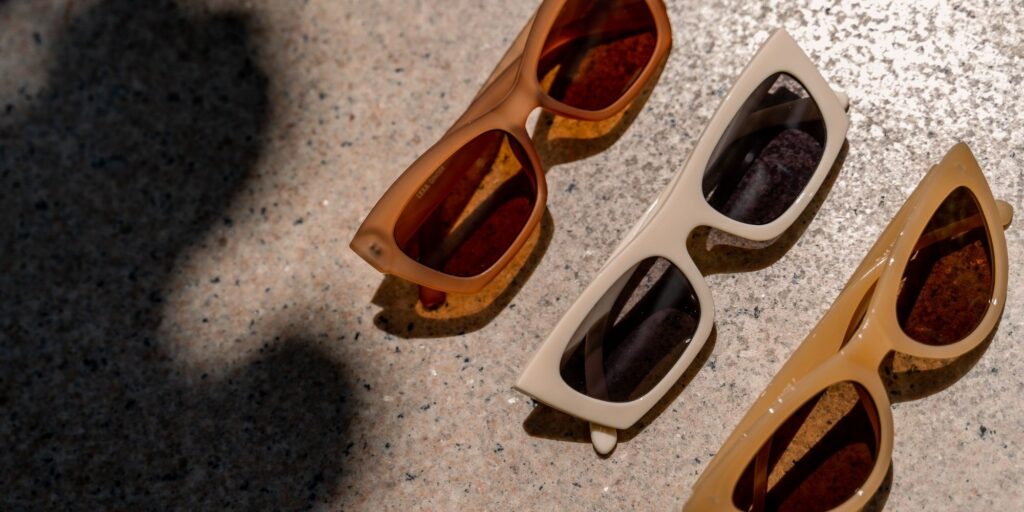 three pairs of sunglasses in different shades of beige.