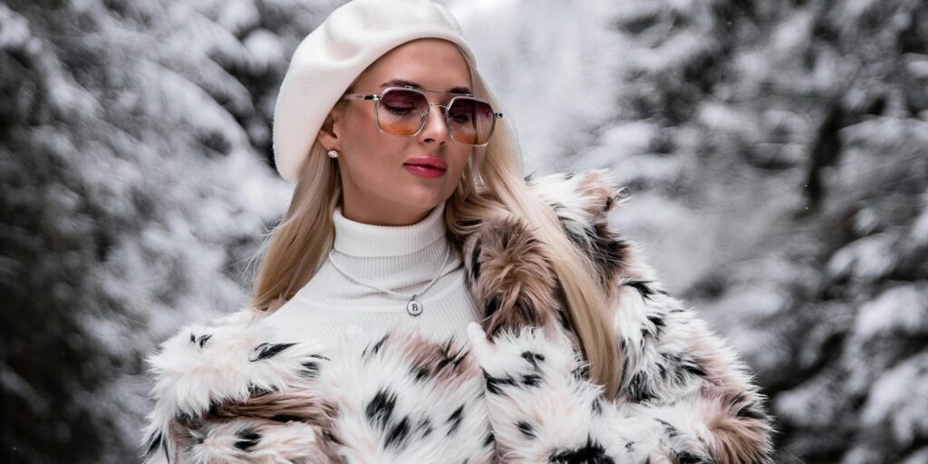 Glamorous woman in a luxe animal fur coat standing in the snow