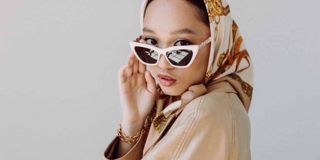 Beautiful Asian woman wearing a headscarf and retro white sunglasses