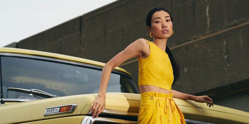 Asian woman standing in front of a taxi posing