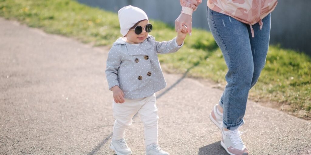 Fashionable toddler in a coat and sunglasses