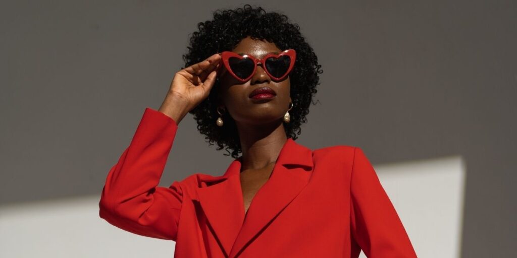 Red heart-shaped sunglasses paired with a bright red suit