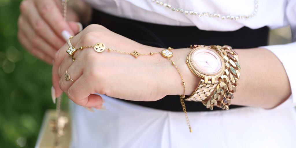 Von Cleef jewelry paired with chunky gold watch and bracelet