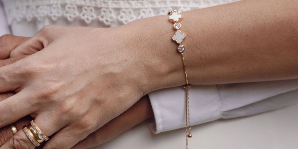 Pink Van cleef bracelet worn on a woman's wrist being hugged by a man