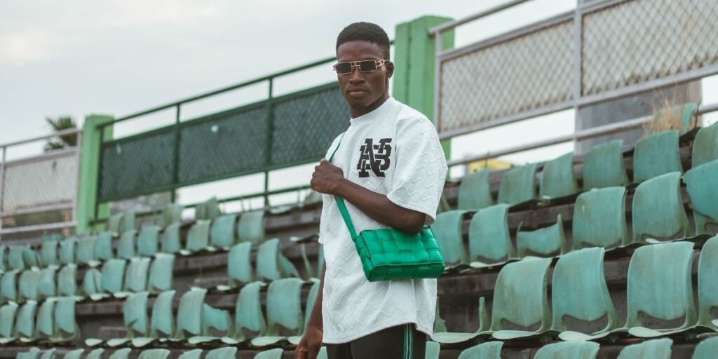 a man wearing a green bottega veneta bag