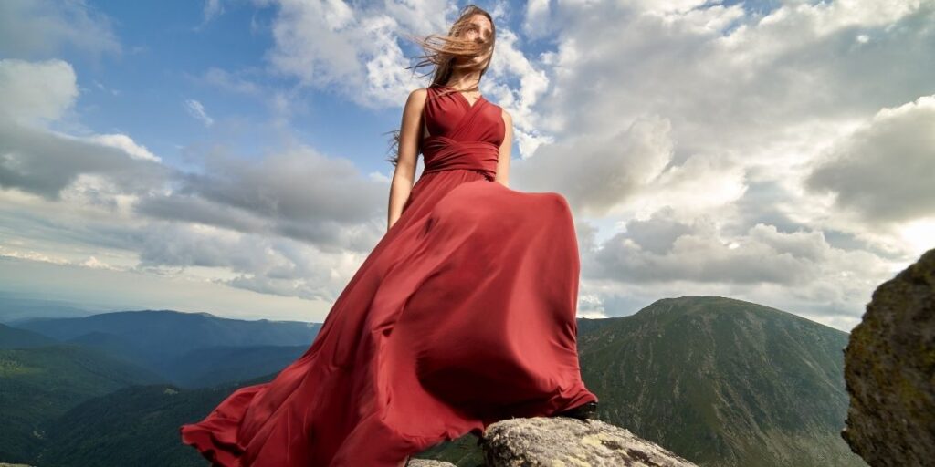 Woman in a red dress on top of a mountain