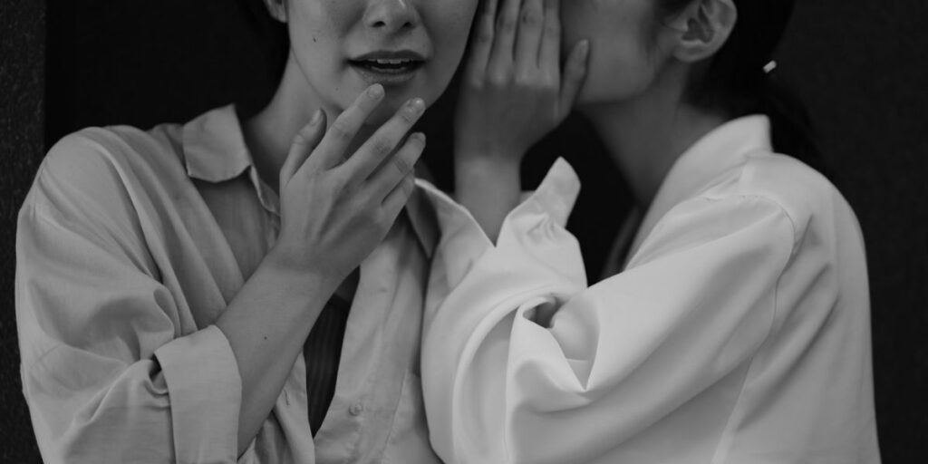 Two women whispering in B/W